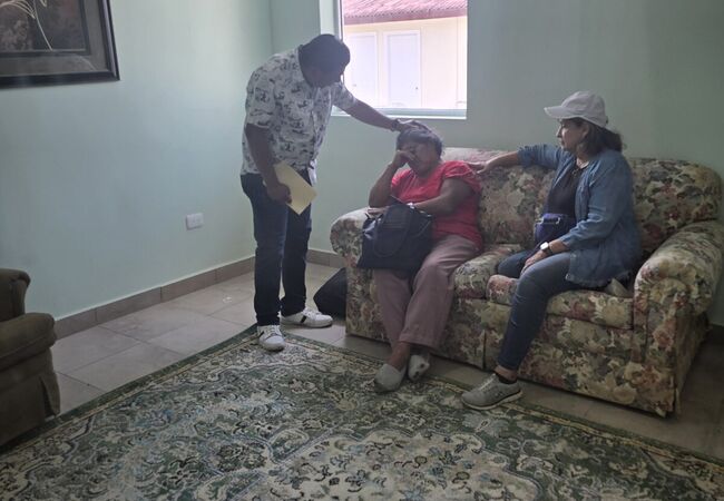 Volunteers and a local pastor pray with a patient at the Medical Mission Brigade