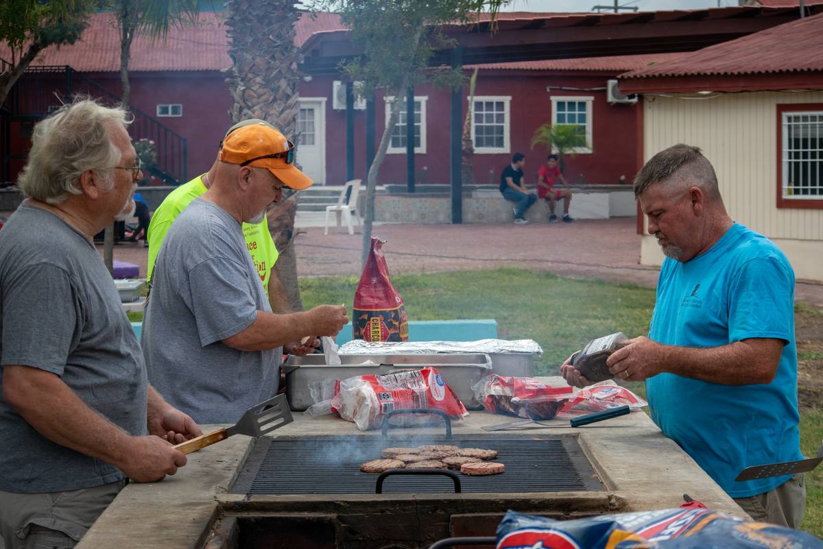 Volunteers grilling hamburgers on the campus patio