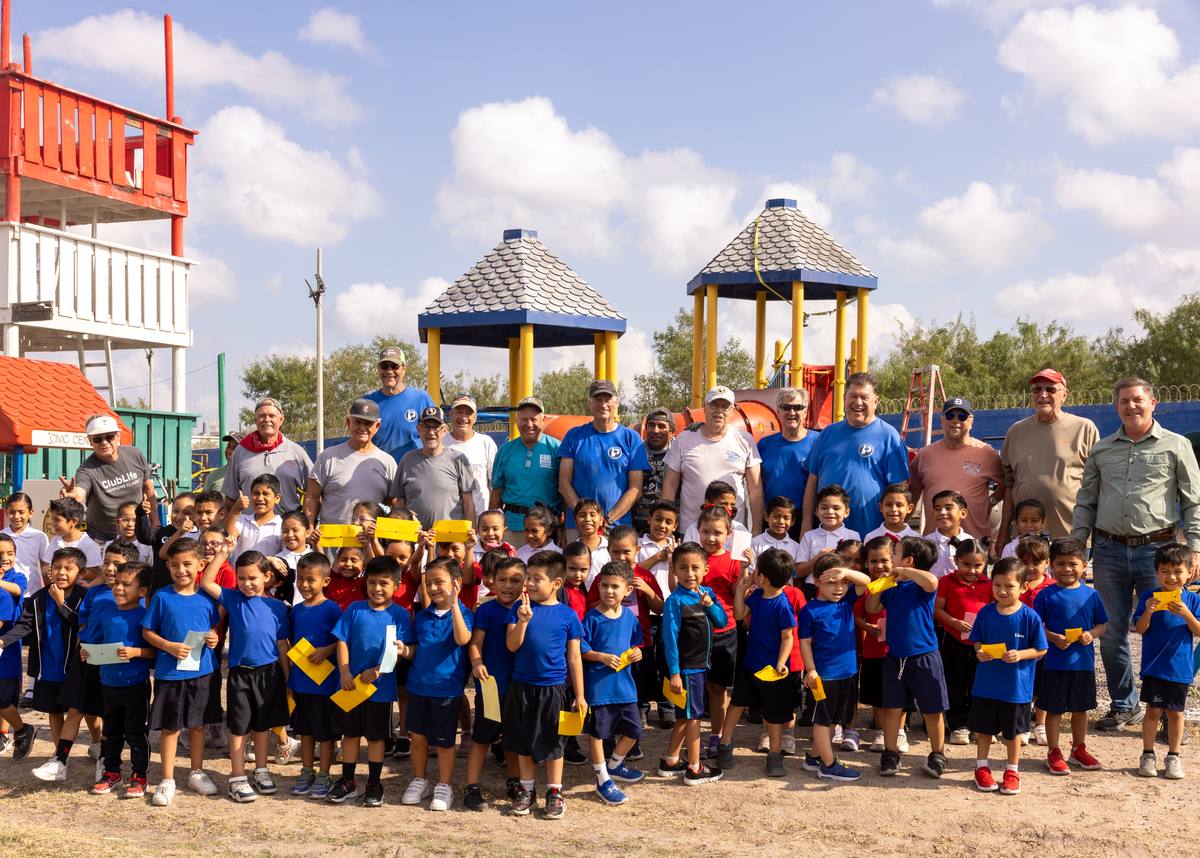 Volunteer mission team and schoolchildren gathered in front of a newly built playground at Rio Bravo Ministries in Reynosa, Mexico