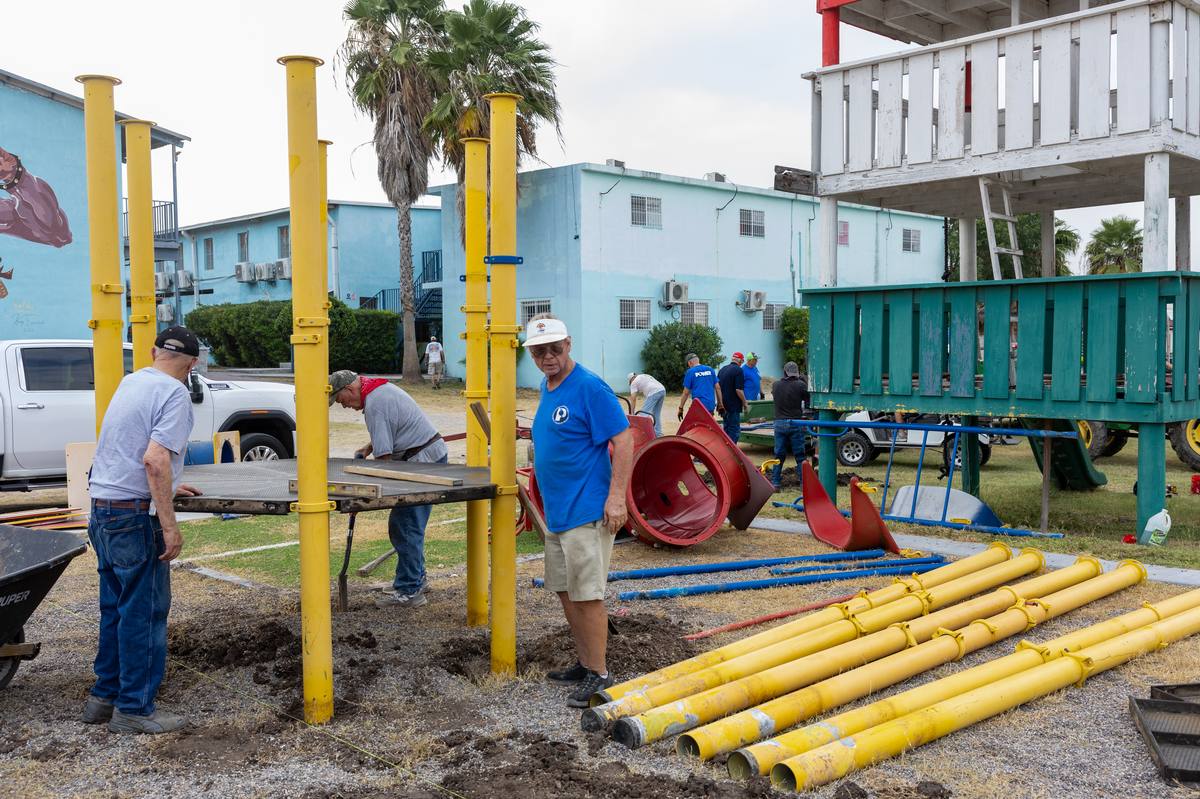 Volunteers setting posts and laying out equipment for a new playground in Reynosa