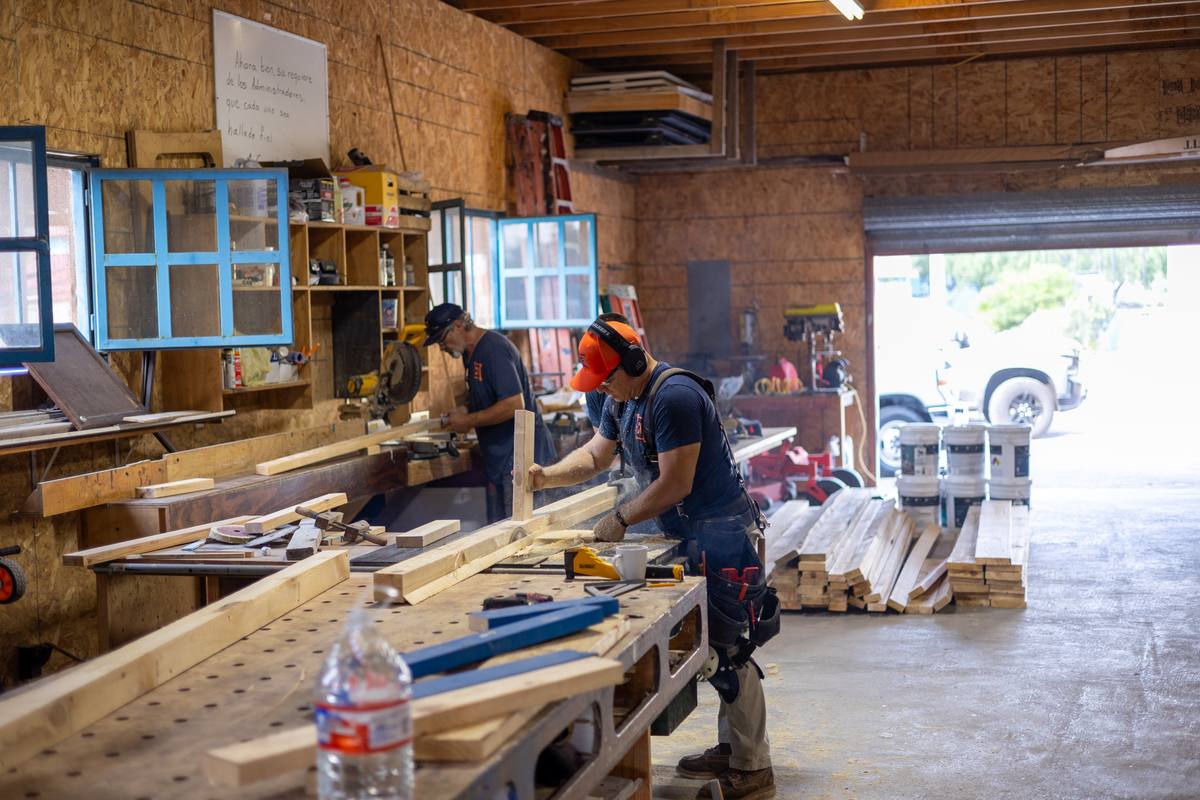 Volunteers cutting and milling lumber in the campus workshop